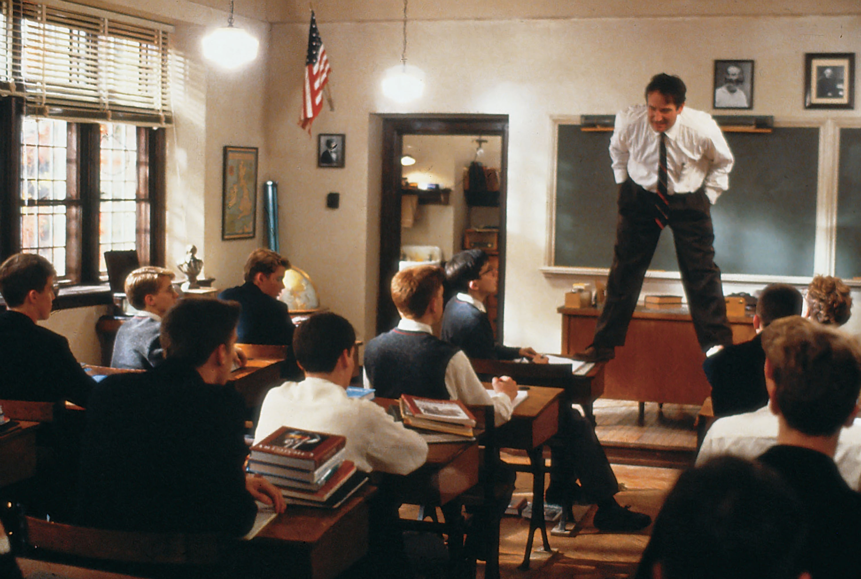 Robin Williams stands on students' desks in a scene from Dead Poets Society.