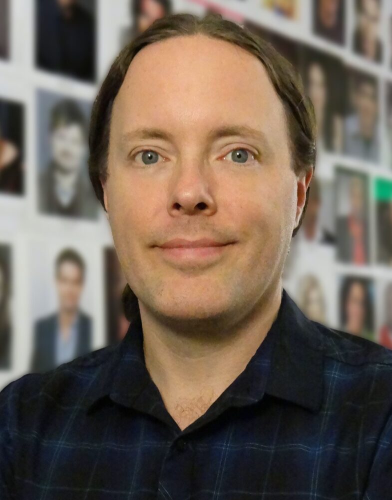 Allen Hooper portrait; headshot of a man with blue eyes and dark hair, wearing a dark blue shirt.