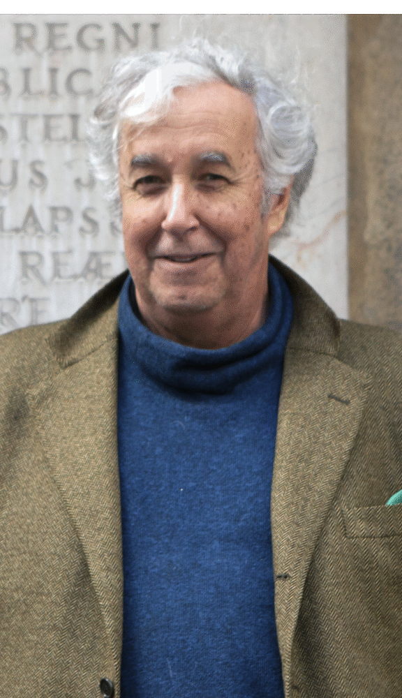 Ricardo Preve, smiling, wearing a blue turtleneck and tweed jacket.