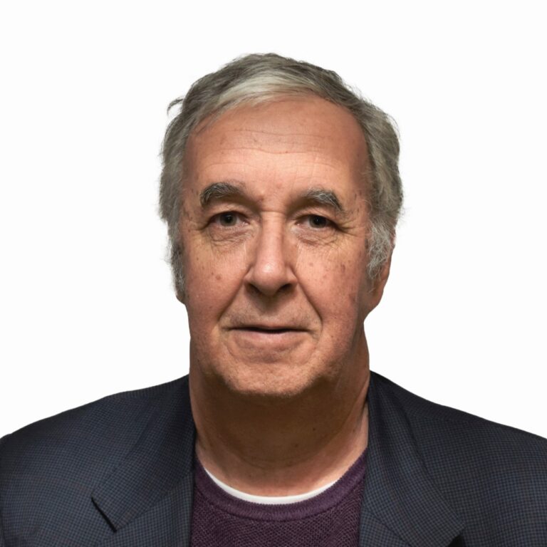 Ricardo Preve, a distinguished gentleman with graying hair, wearing a dark jacket over a purple sweater.