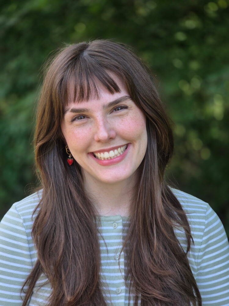 Peyton McCarthy smiling outdoors in a green striped shirt