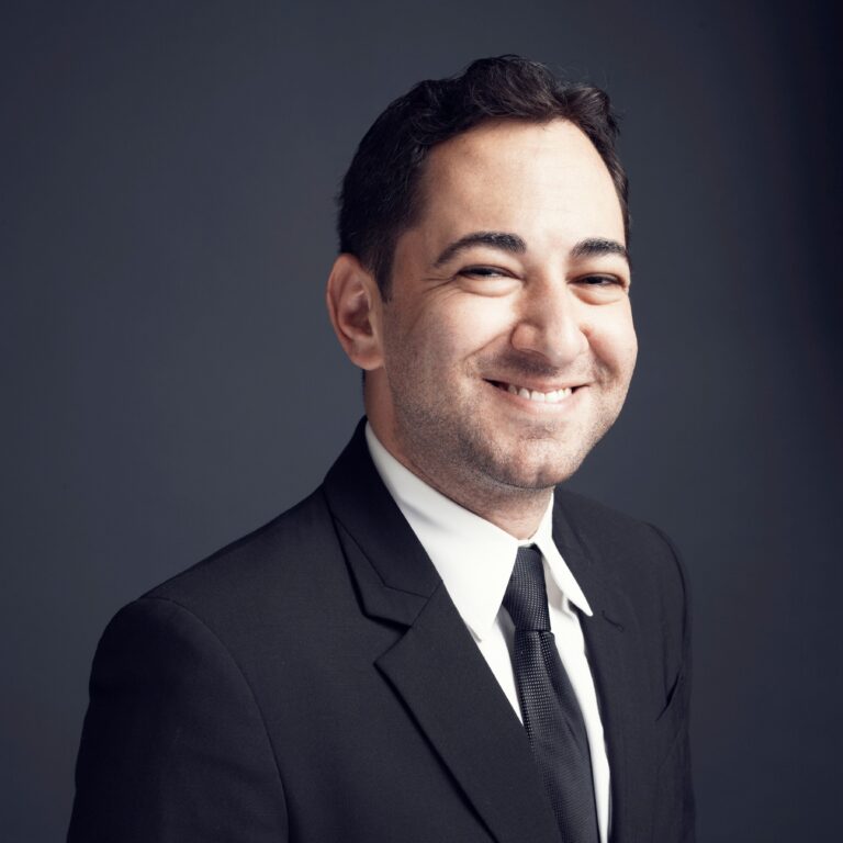 Scott Feinberg, a man in a black suit, smiles warmly.