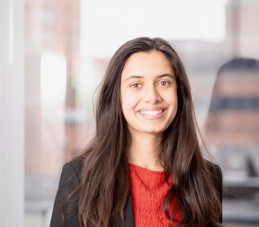 Anika Kashyap, a young woman with long dark hair, smiles in a professional setting.