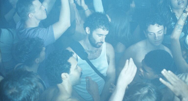 Club kid scene: diverse group of young adults dancing in blue-lit club