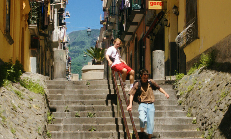 Two young men descend steep stone stairs in an Italian alleyway, "La Gradiva