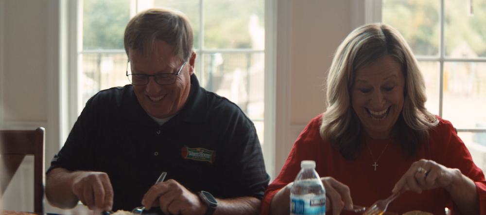 Couple laughing while eating a meal at a table