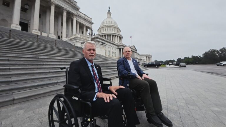 Two men in wheelchairs outside the U.S. Capitol building.