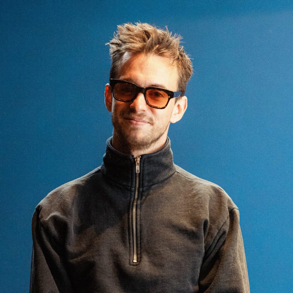 Andrew Hebert wearing sunglasses and a quarter-zip sweatshirt