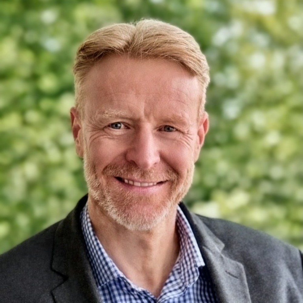 Christopher Golding, smiling man with blonde hair and beard, wearing a suit