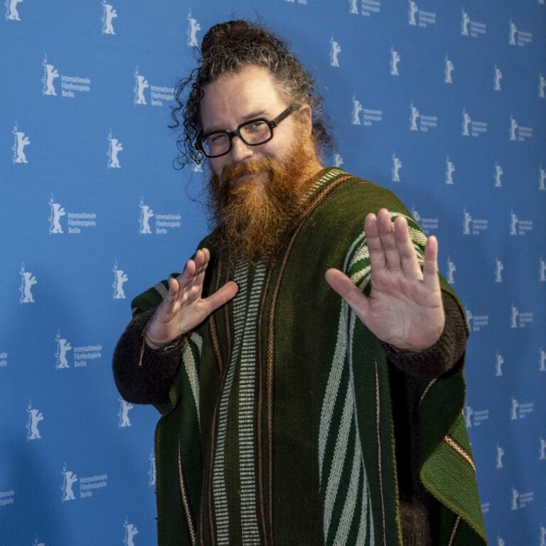 Cristóbal Tapia de Veer at Berlinale, wearing a green poncho and glasses.