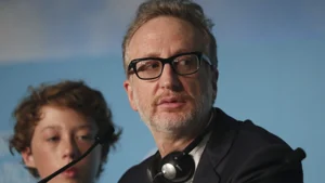 Man in glasses and suit with headphones, boy in foreground