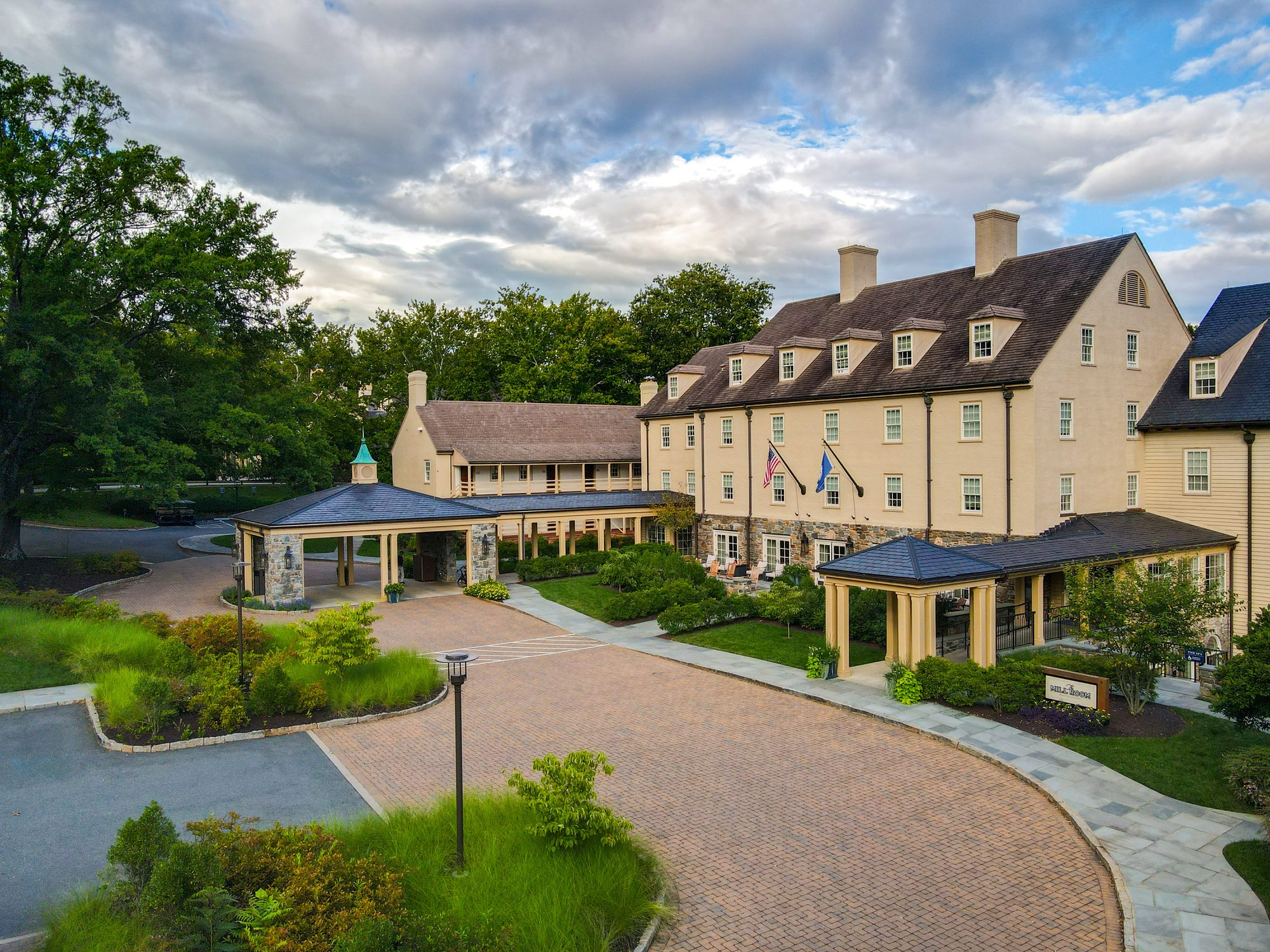 Exterior of The Inn at Willow Grove, a luxury hotel with a circular driveway and lush landscaping.