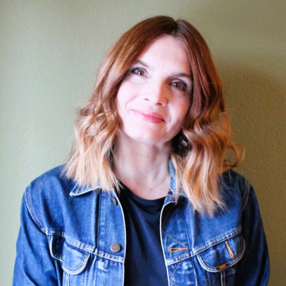 Iana Dontcheva smiling in a denim jacket.