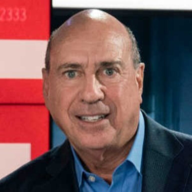 John Terenzio, a bald man with a blue shirt and dark jacket, smiles at the camera.