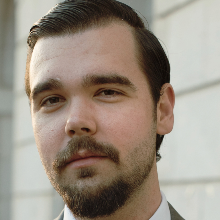 Justin MacFayden portrait, man with beard and mustache in suit