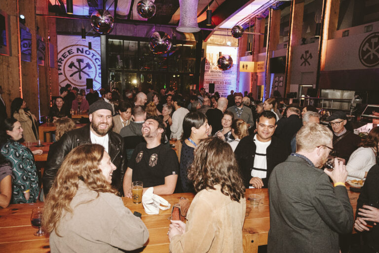 People enjoying drinks and conversation at a late night wrap party.