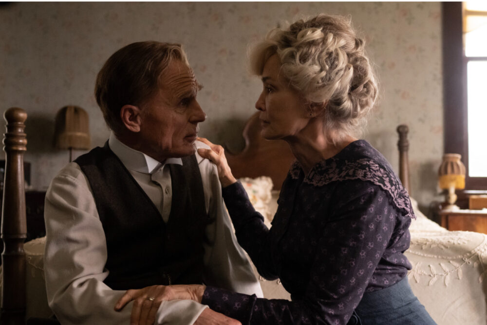 Couple in period clothing in a dimly lit room, possibly from "Long Day's Journey Into Night.
