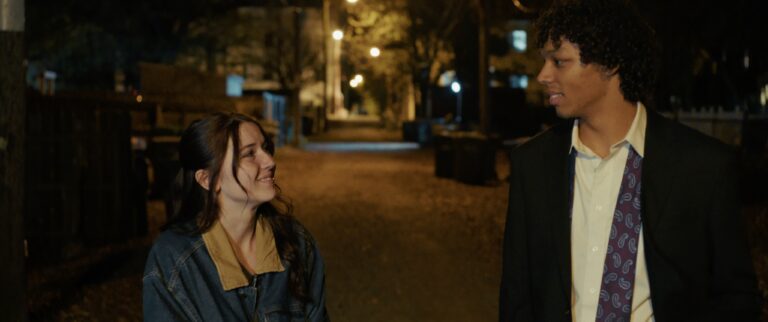 Young couple walks at night, discussing their last day.