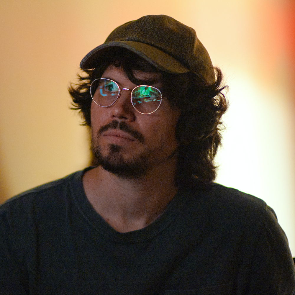 Michael Gallagher wearing a cap and glasses, with reflections in the lenses