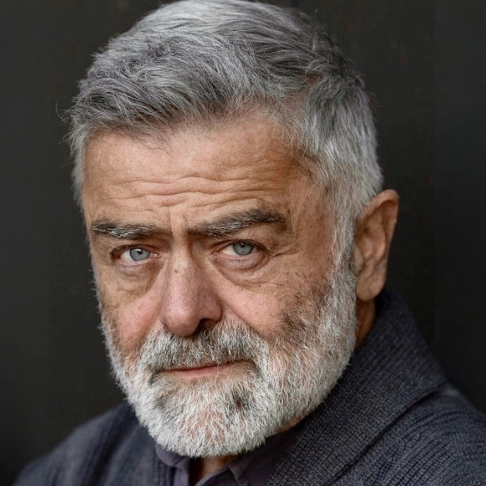 Michael Marundé, a distinguished man with gray hair and beard, looking directly at the camera.