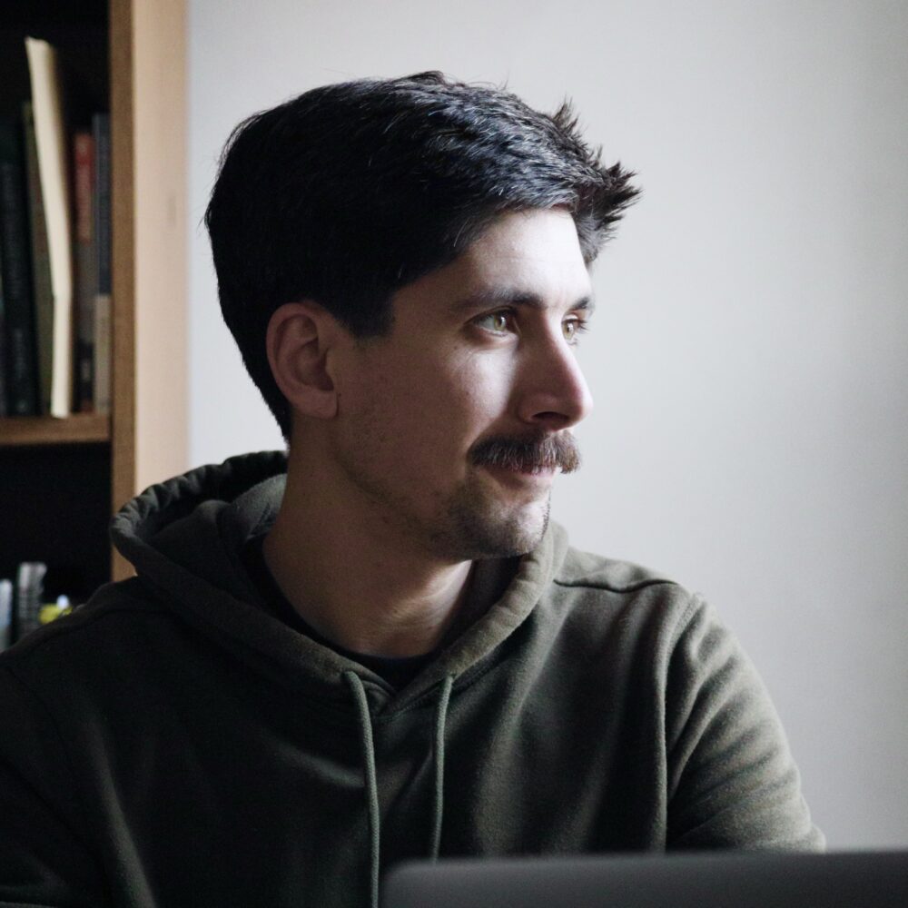 Stephen Brouillette, a man with a mustache, wearing a green hoodie.
