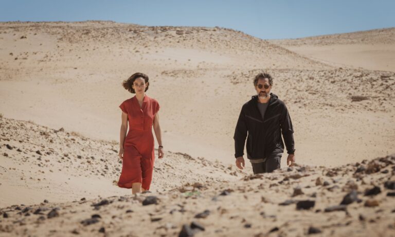 Couple walking through a barren desert landscape, inspired by "The Beloved