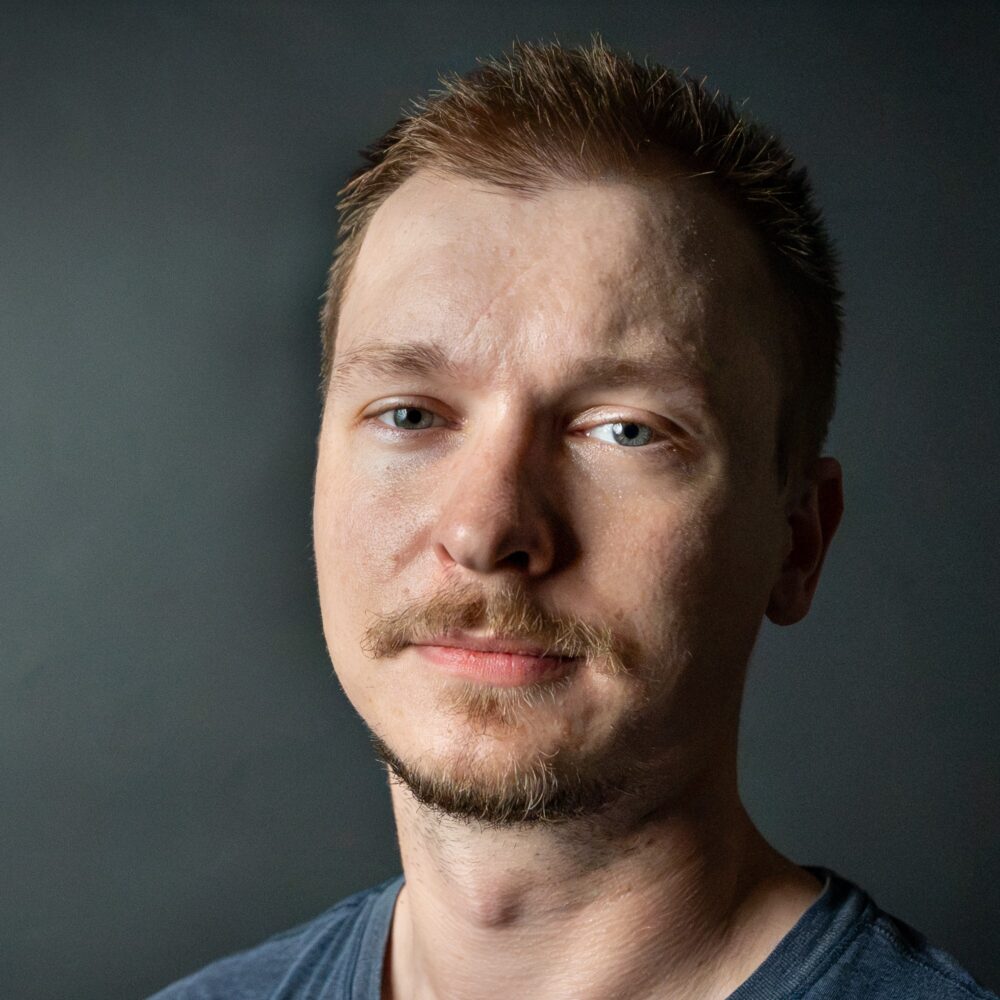 Tarik Begic, a man with short brown hair and a mustache, looks directly at the camera.