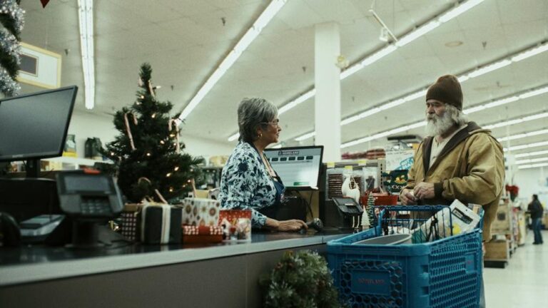 Man with beard and beanie at grocery checkout with Christmas tree