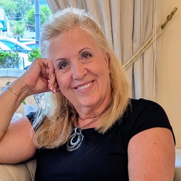 Janice Blanock smiling, with her head resting on her hand.
