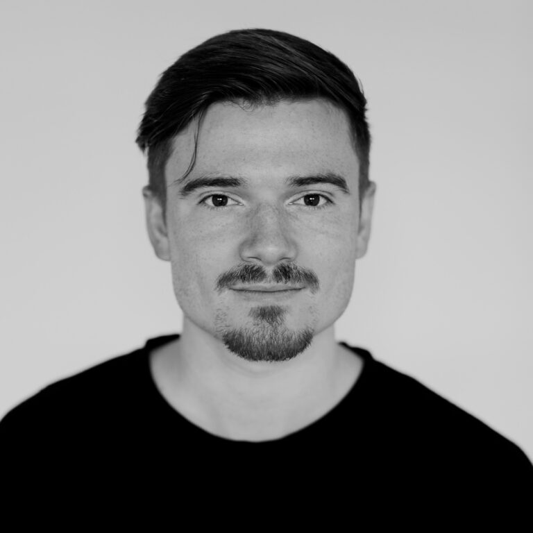 Sean Raynor, a man with a mustache and goatee, looking directly at the camera.